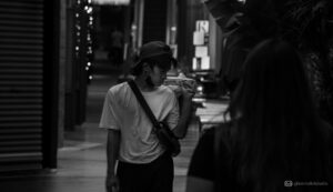 A boy with food on the street - GM Creative Studio - Black and white street photography